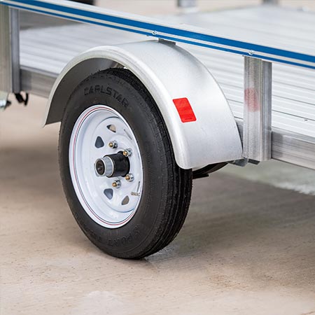 A close-up photo showing a rail side utility trailer and wheel.