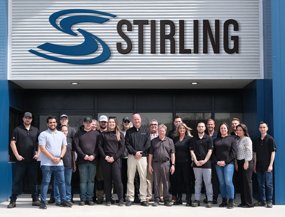 A group photo of employees of Stirling Trailers, outdoors in front of the Stirling Trailers office and manufacturing facility.