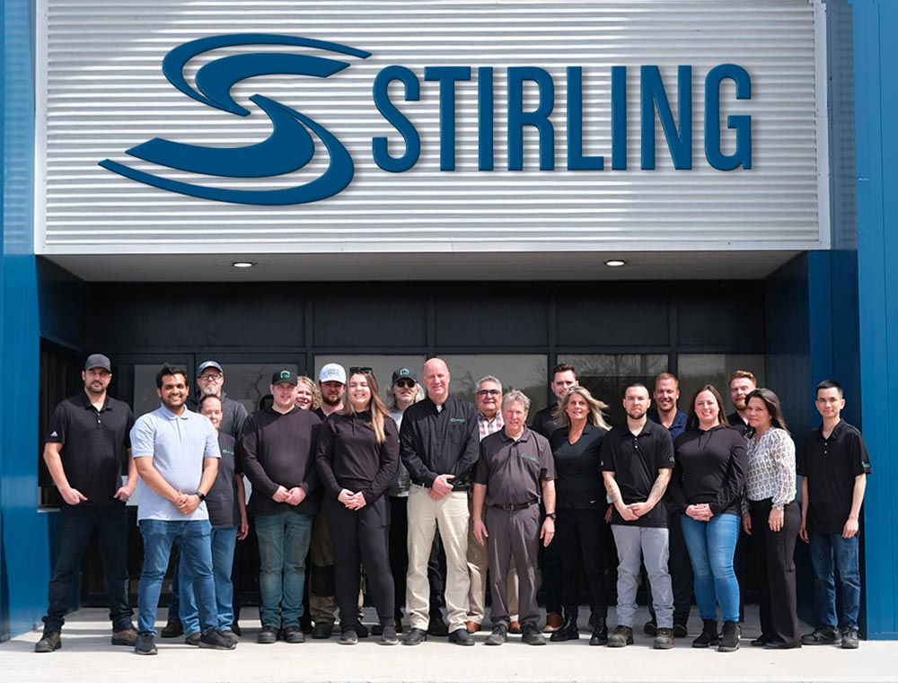 A group photo of Stirling Trailers employees, outdoors in front of the Stirling Trailers office and manufacturing facility.